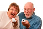 Tipos de videojuegos para la tercera edad Una pareja mayor juega con la wii