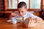 Trucos para combatir la mucositis y odinofagia en el cáncer infantil Niño con cáncer con mucositis intentando comer