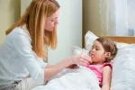 Tratamiento de la infección por norovirus y prevención Madre dando agua a su hija para recuperarse del norovirus