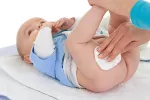 Productos para la higiene de la zona del pañal Una mamá le limpia el culito a su bebé