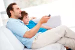 Un padre y su hijo ven juntos la televisión