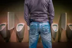 Hombre orinando en un baño público
