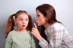 Madre cuchicheando a su hija