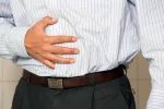 Síntomas de hígado graso Hombre se toca el abdomen dolorido