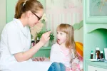 Tratamiento de la roséola y prevención Médico suministrando medicamentos a una niña