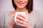 Asocian consumo de café y menor riesgo de melanoma Mujer con una taza de café
