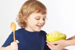 Niño consumiendo mijo Niño comiendo un tazón de mijo