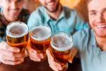 El consumo de cerveza previene la aterosclerosis Hombres sostienen jarras de cerveza
