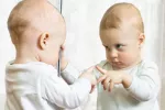 Cuándo comienza a ver el bebé Un bebé se mira en el espejo