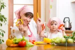 Dieta mediterránea reduce riesgo obesidad infantil Una madre y su hija muestran alimentos típicos de la dieta mediterránea