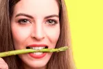 Glutatión, un antioxidante que afecta al atractivo Una mujer muerde un espárrago verde