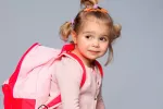 Primeros días de colegio Niña con la cartera preparada para ir al colegio