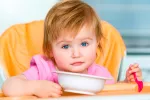 La OMS aconseja reducir la sal en los alimentos infantiles Niña pequeña comiendo