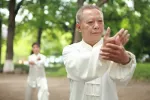 Movimiento de taichi Anciano practicando movimientos de taichi