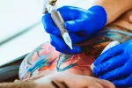 Advierten de posibles riesgos al hacerse tatuajes Un profesional realizando un tatuaje de colores