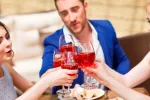 ¿Previene el alcohol algunas enfermedades cardiovasculares? Amigos brindando con copas de vino tinto
