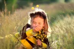 Más niños con alergia al polen por el cambio climático Niña pequeña estornudando en el campo