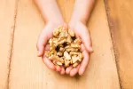 Las nueces son el fruto seco que más alergias provoca en los niños Niño cogiendo con las manos nueces
