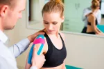 Aplicar mal la kinesioterapia puede causar problemas Un fisioterapeuta aplica vendas de kinesiotaping a una paciente
