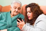 Una app detecta el deterioro cognitivo y ejercita la mente Una joven muestra la pantalla de un móvil a una anciana