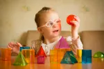 Los síntomas del síndrome de Down pueden mejorar Niña con Sindrome de Down aprendiendo
