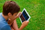 Asocian abuso de pantallas y bajo rendimiento escolar Un niño consulta una tablet