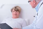 Asocian amiloidosis senil e insuficiencia cardiaca Mujer mayor en la cama junto a su médico