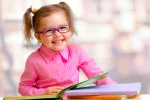 La atropina puede reducir la progresión de miopía en niños Niña pequeña con gafas sonriendo a la cámara