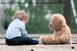 Niño autista sentado con su peluche