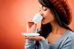 El café protege el corazón y previene diabetes y párkinson Una joven tomándose una taza de café