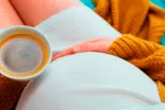 Mujer embarazada tomando café