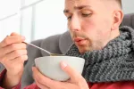 Persona con catarro tomando caldo de jamón
