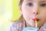 Los zumos infantiles tienen demasiado azúcar Una niña tomándose un zumo envasado en un tetrabrik