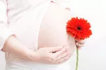 La dieta de la madre marca la salud genética del futuro bebé Mujer embarazada sosteniendo una flor
