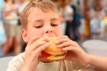 La dieta en la infancia afecta a la salud en la edad adulta Un niño comiéndose una hamburguesa