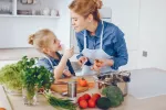 La dieta mediterránea mejora la microbiota mamaria y protege del cáncer Madre e hija preparando comida mediterránea