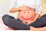 Un nuevo dispositivo predice la necesidad de inducir el parto Vientre de una embarazada pintado con una cara feliz