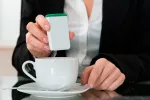 Tomar edulcorantes artificiales podría aumentar la grasa corporal Mujer echando edulcorante en el café