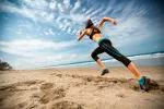 Entrenar más de 5 días a la semana propicia lesiones Una mujer corre en una playa