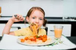 Una niña come espaguetis