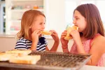 En España se consume el 50% del pan recomendado Dos niñas comen pan tostado