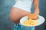 El feto puede volverse adicto a la 'comida basura' Embarazada comiendo comida basura