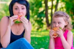 Madre e hija comiendo hamburguesa