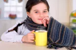 El jengibre ayuda a tratar el vómito en niños con gastroenteritis Niña tomando una infusión de jengibre para aliviar la gastroenteritis