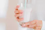 Mujer tomando vaso de leche entera