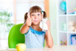 La leche entera es más saludable para los niños Niña bebiendo un vaso de leche entera