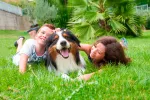Niños jugando con su perro en el jardín