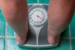 Descubren cómo activar la grasa parda para luchar contra la obesidad Mujer con problemas de obesidad pesándose