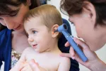 La otitis afecta al 90% de los niños menores de cinco años Doctora examina a niña pequeña con otitis