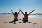 Practicar nudismo puede hacernos más felices Pareja feliz haciendo nudismo en la playa